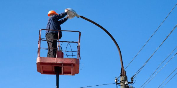 electrician climb work installing electrician climb work installing new street lamp on electricity power concrete pole in blue sky